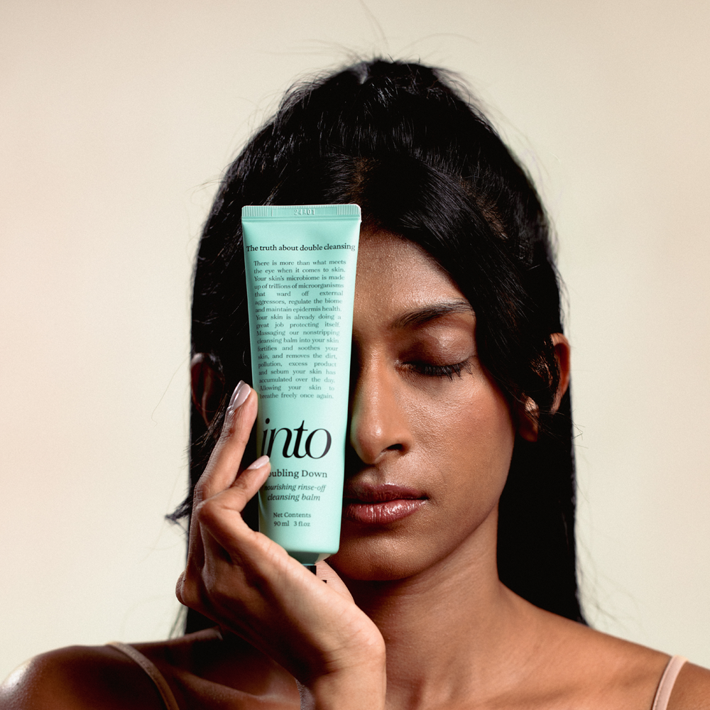 Female Model holiding cleansing balm close to the face.